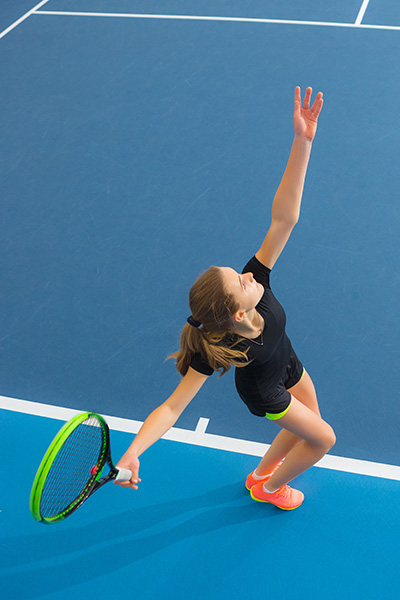 young girl closed tennis court with ball