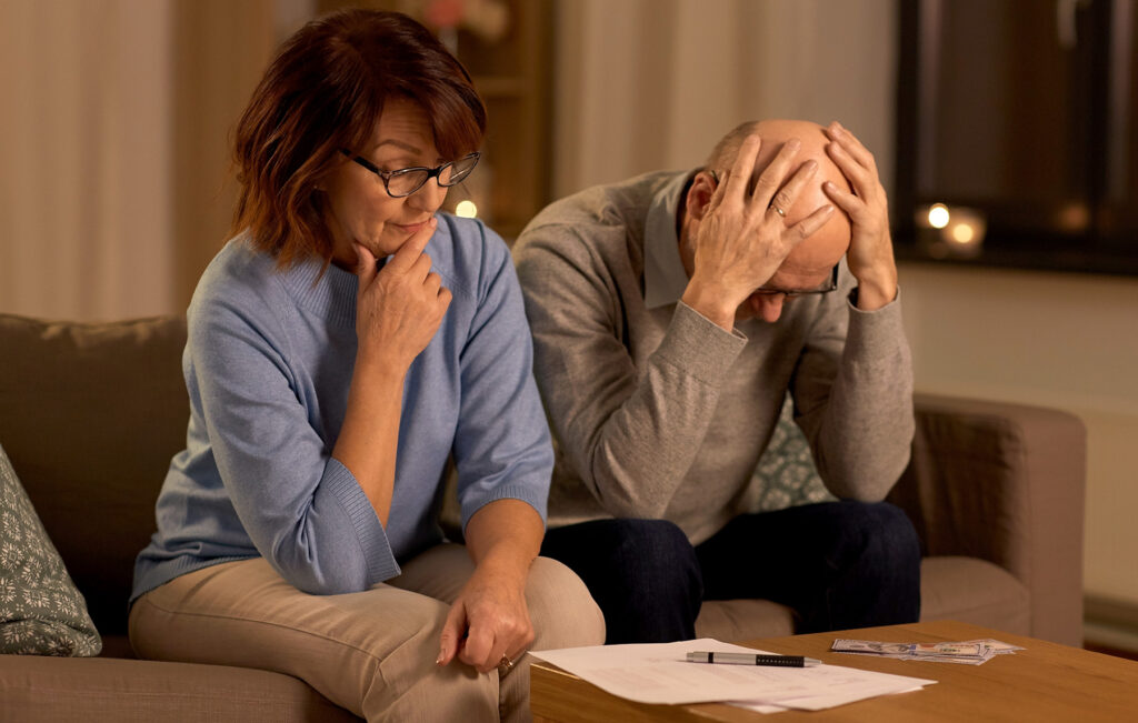 unhappy senior couple with bills money home
